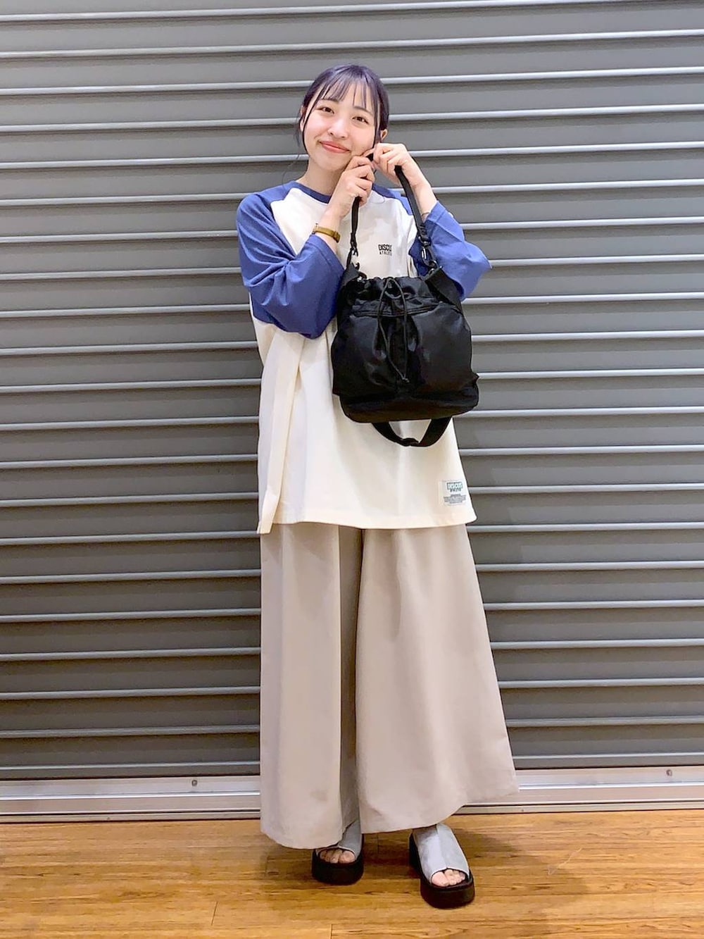 ブルー系のTシャツ/カットソー、ベージュ系のその他パンツ、ブラック系のショルダーバッグを着用したレディースの春コーディネートの4枚目の写真