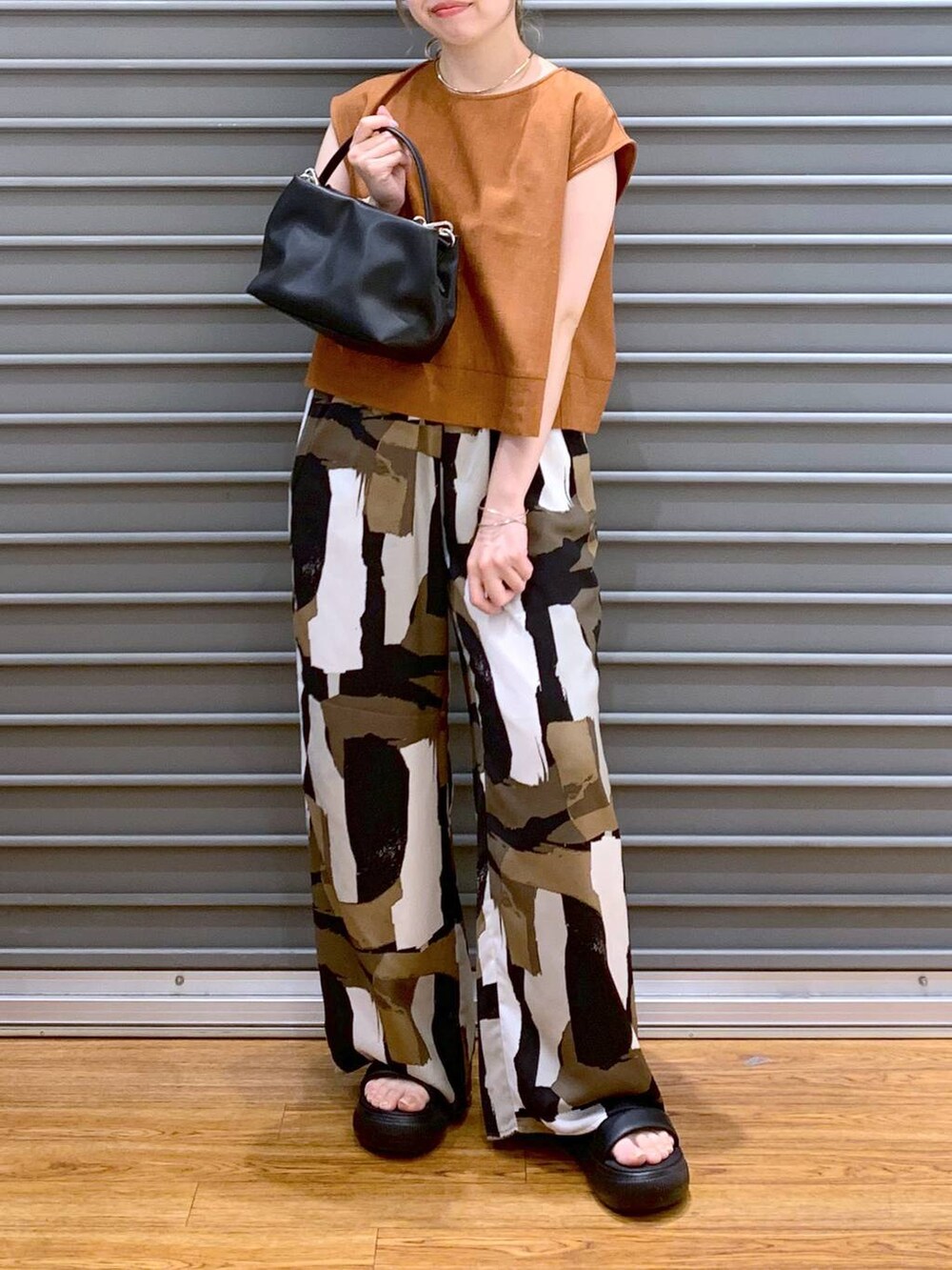 ブラック系のサンダル、オレンジ系のシャツ/ブラウス、ブラック系のショルダーバッグを着用したレディースの夏コーディネートの5枚目の写真