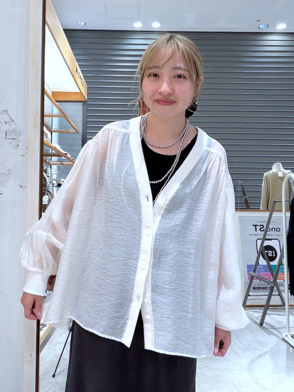 ベージュ系のシャツ/ブラウス、ブラック系のスカート、ブラック系のパンプスを着用したレディースの春コーディネートの6枚目の写真