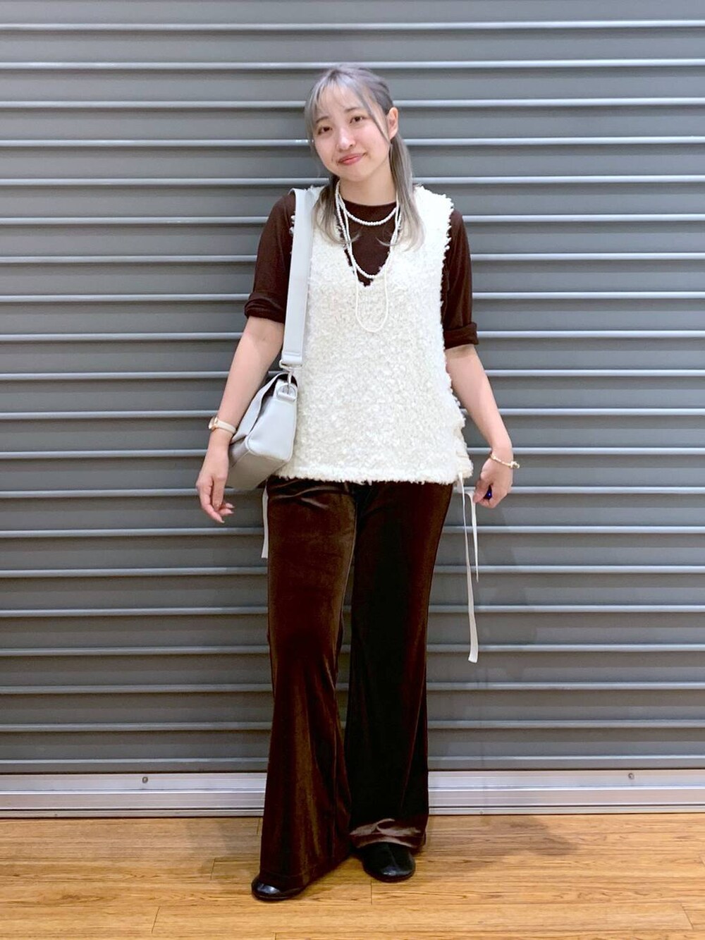 ブラウン系のその他パンツ、グレー系のショルダーバッグ、ホワイト系のベストを着用したレディースの秋コーディネートの5枚目の写真