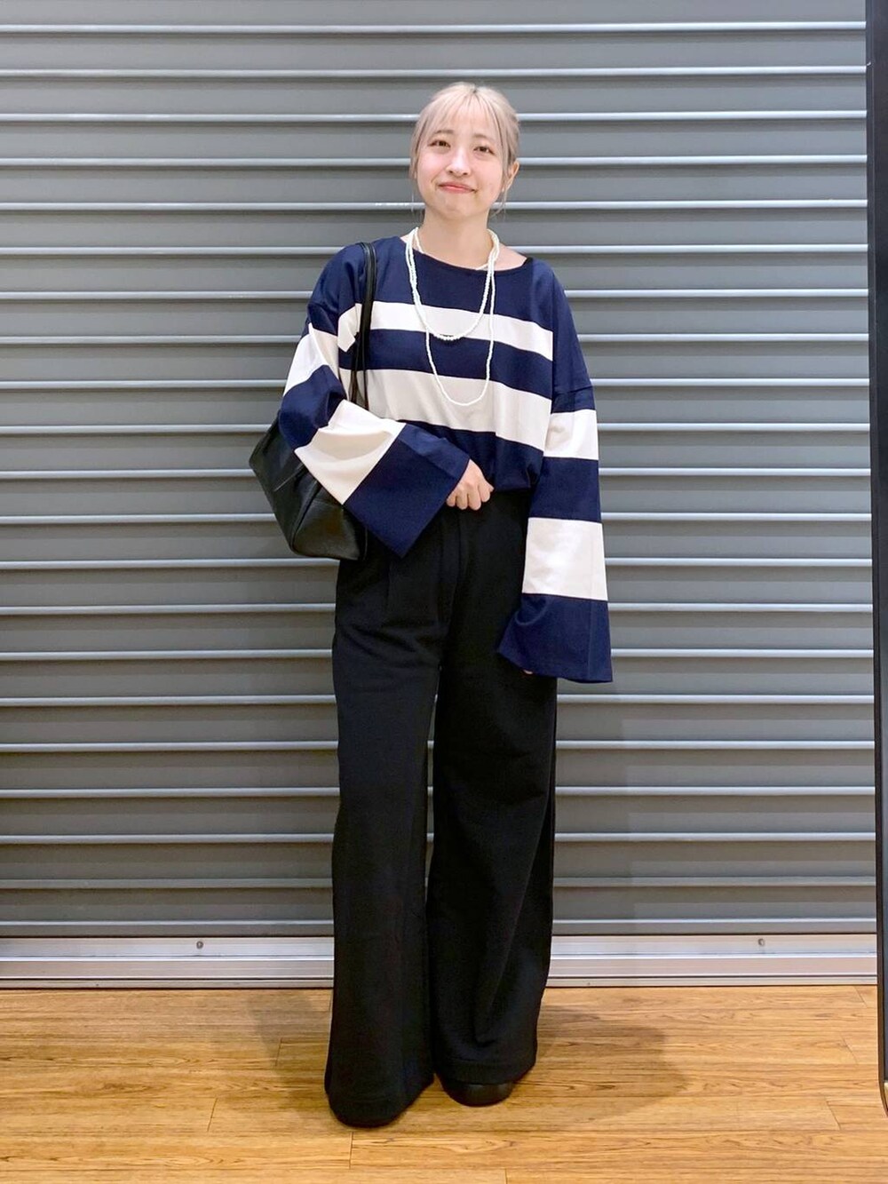 ブラック系のスウェットパンツ、ブラック系のサンダル、ブルー系のTシャツ/カットソーを着用したレディースの秋コーディネートの6枚目の写真