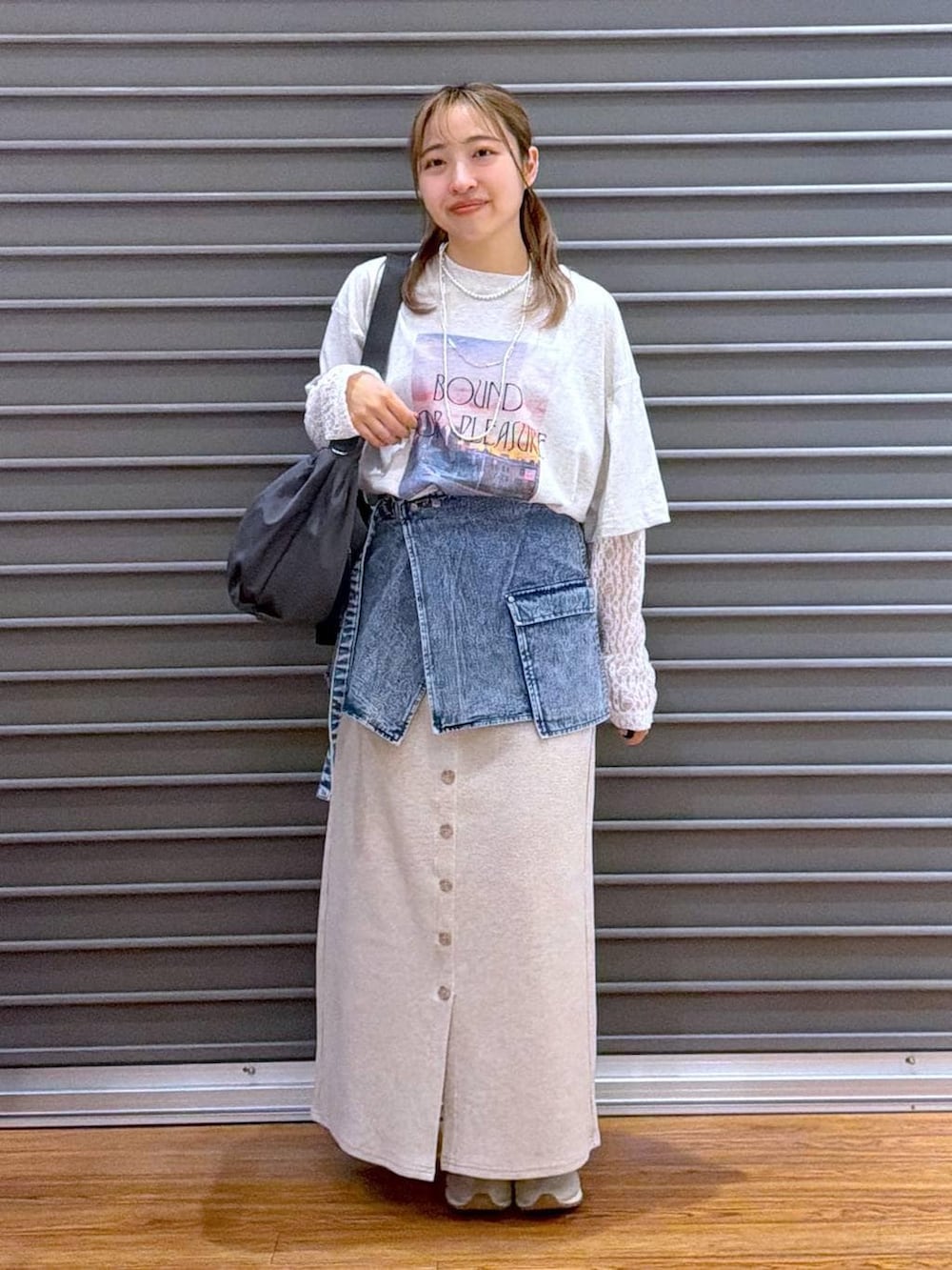 ベージュ系のスカート、ホワイト系のスニーカー、グレー系のショルダーバッグを着用したレディースの春コーディネートの4枚目の写真