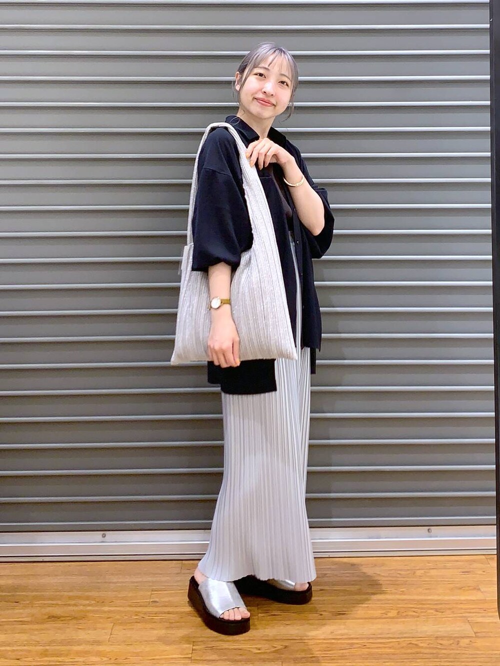 グレー系のスカート、シルバー系のショルダーバッグ、ブルー系のシャツ/ブラウスを着用したレディースの春コーディネートの5枚目の写真