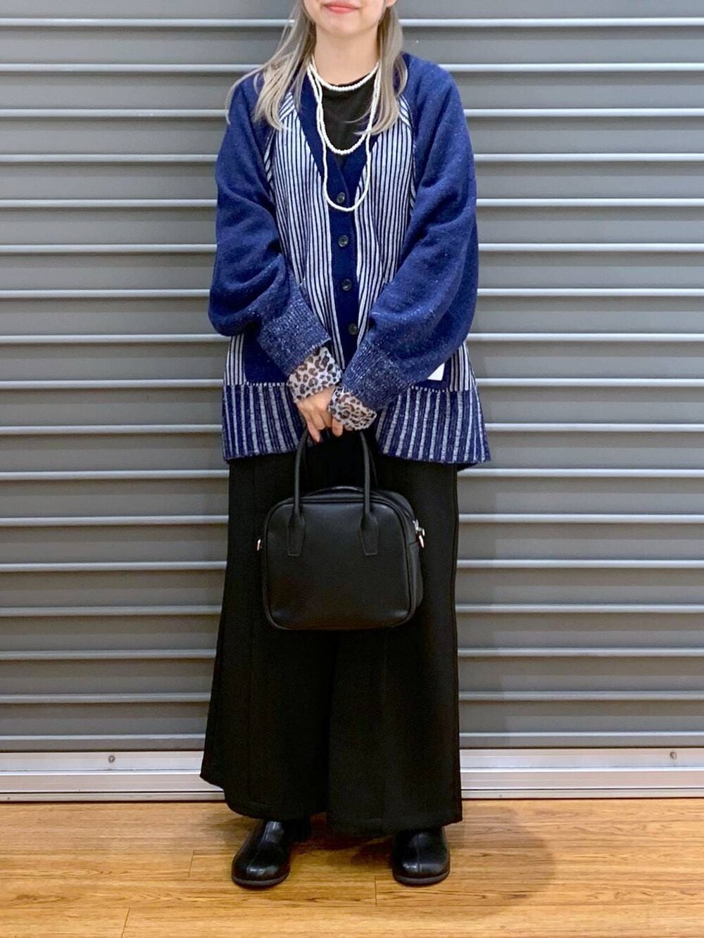 ブラック系のTシャツ/カットソー、ブルー系のカーディガン/ボレロ、ブラック系のボストンバッグを着用したレディースの冬コーディネートの5枚目の写真