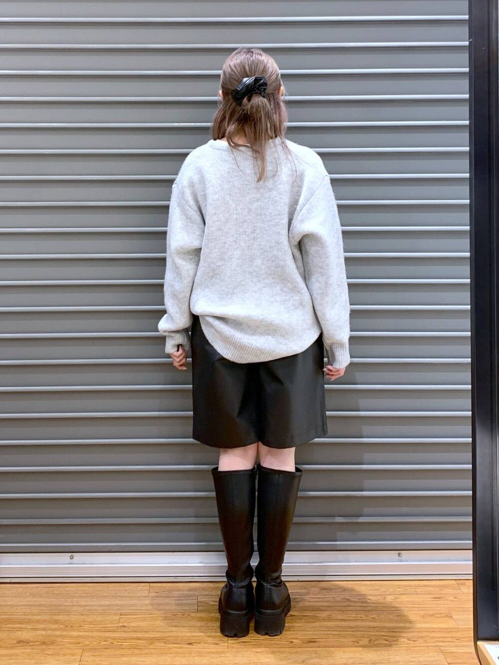 シルバー系のトートバッグ、ブラック系のブーツ、ブラック系のその他パンツを着用したレディースの冬コーディネートの2枚目の写真