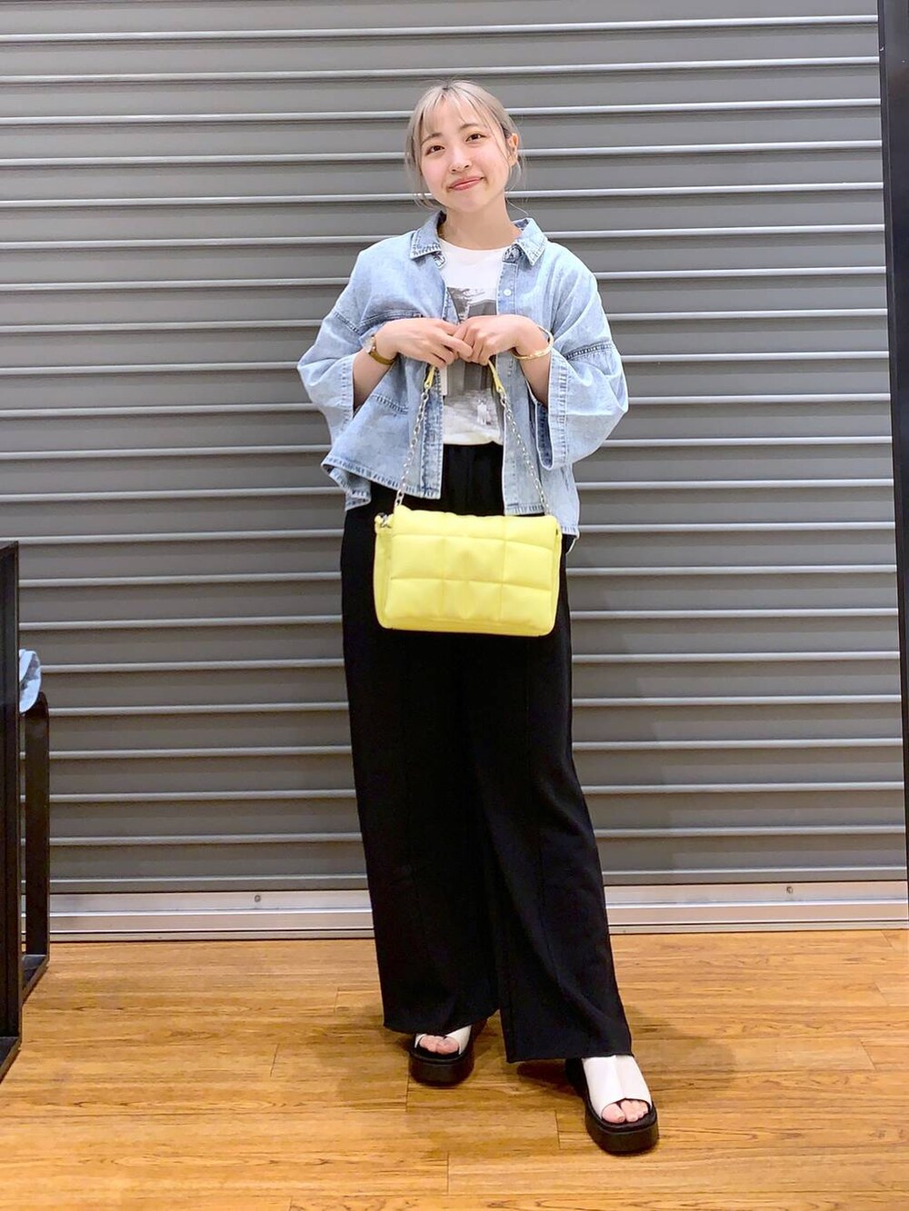 イエロー系のショルダーバッグ、ブルー系のシャツ/ブラウス、ホワイト系のサンダルを着用したレディースの春コーディネートの7枚目の写真