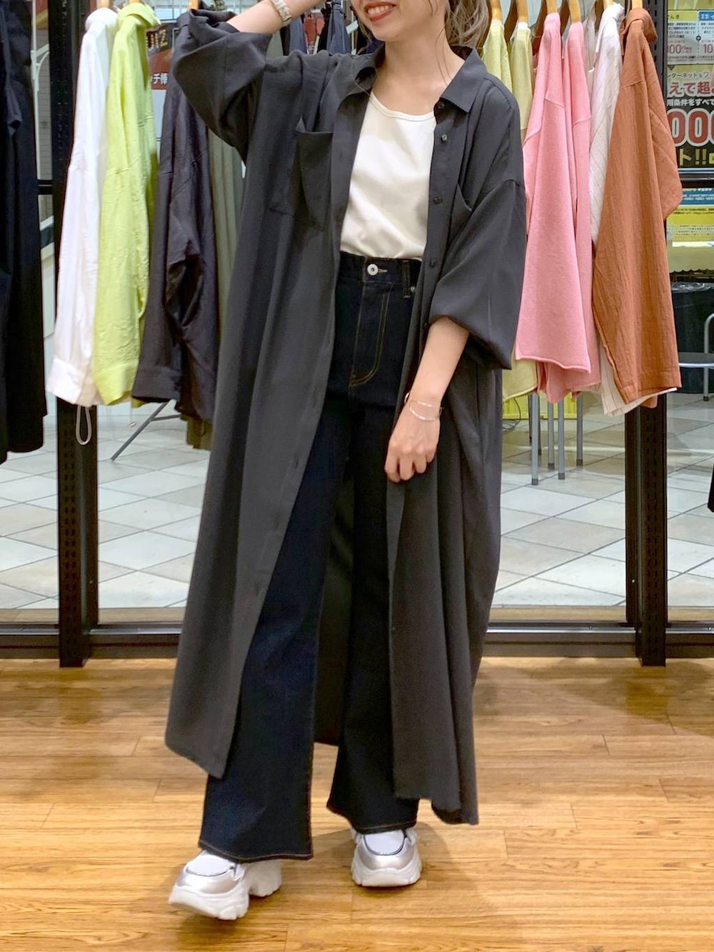 グレー系のワンピース、ホワイト系のタンクトップ、ブルー系のデニムパンツを着用したレディースの春コーディネートの6枚目の写真