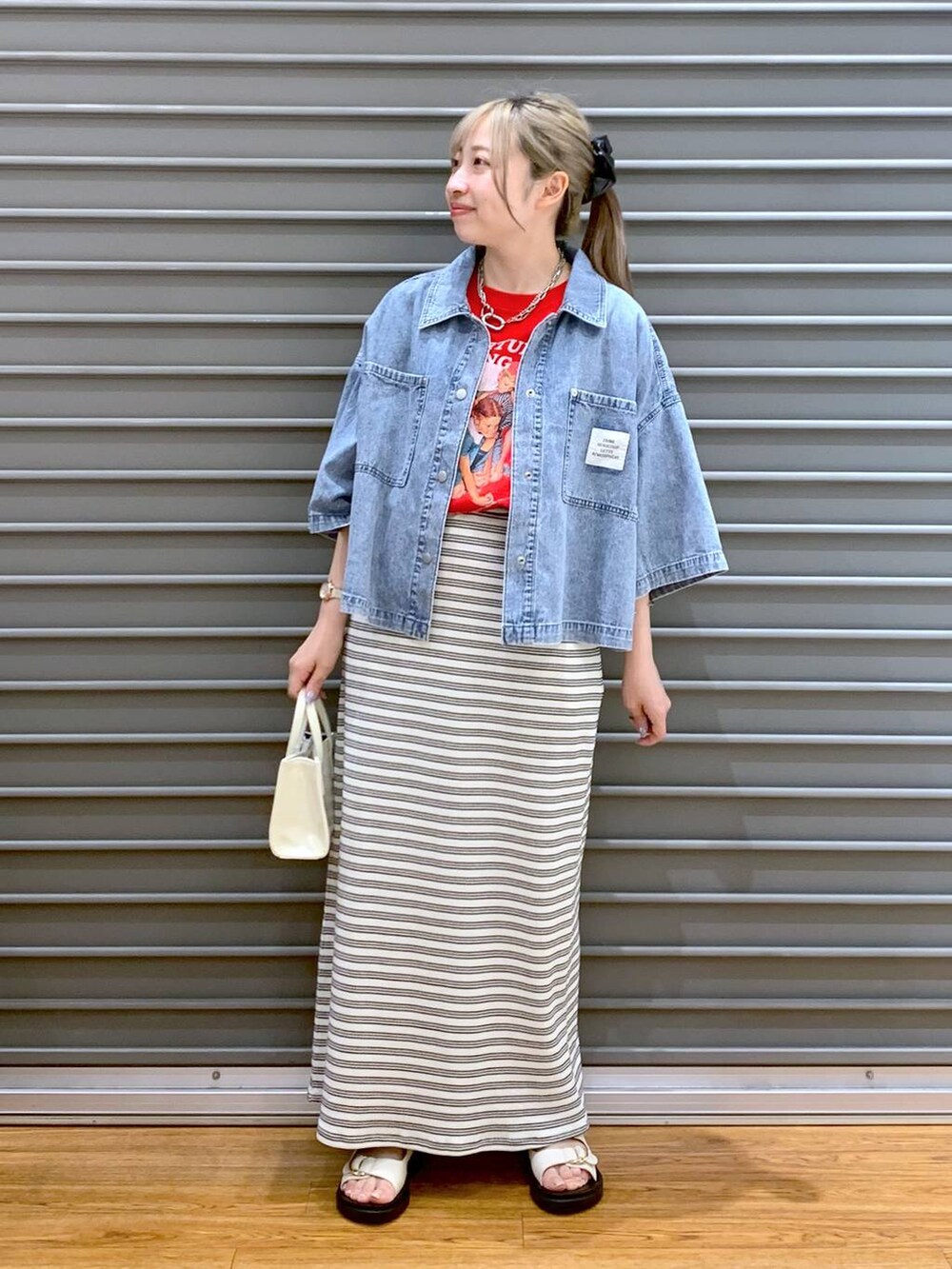 ブラック系のスカート、ホワイト系のサンダル、ホワイト系のショルダーバッグを着用したレディースの夏コーディネートの5枚目の写真