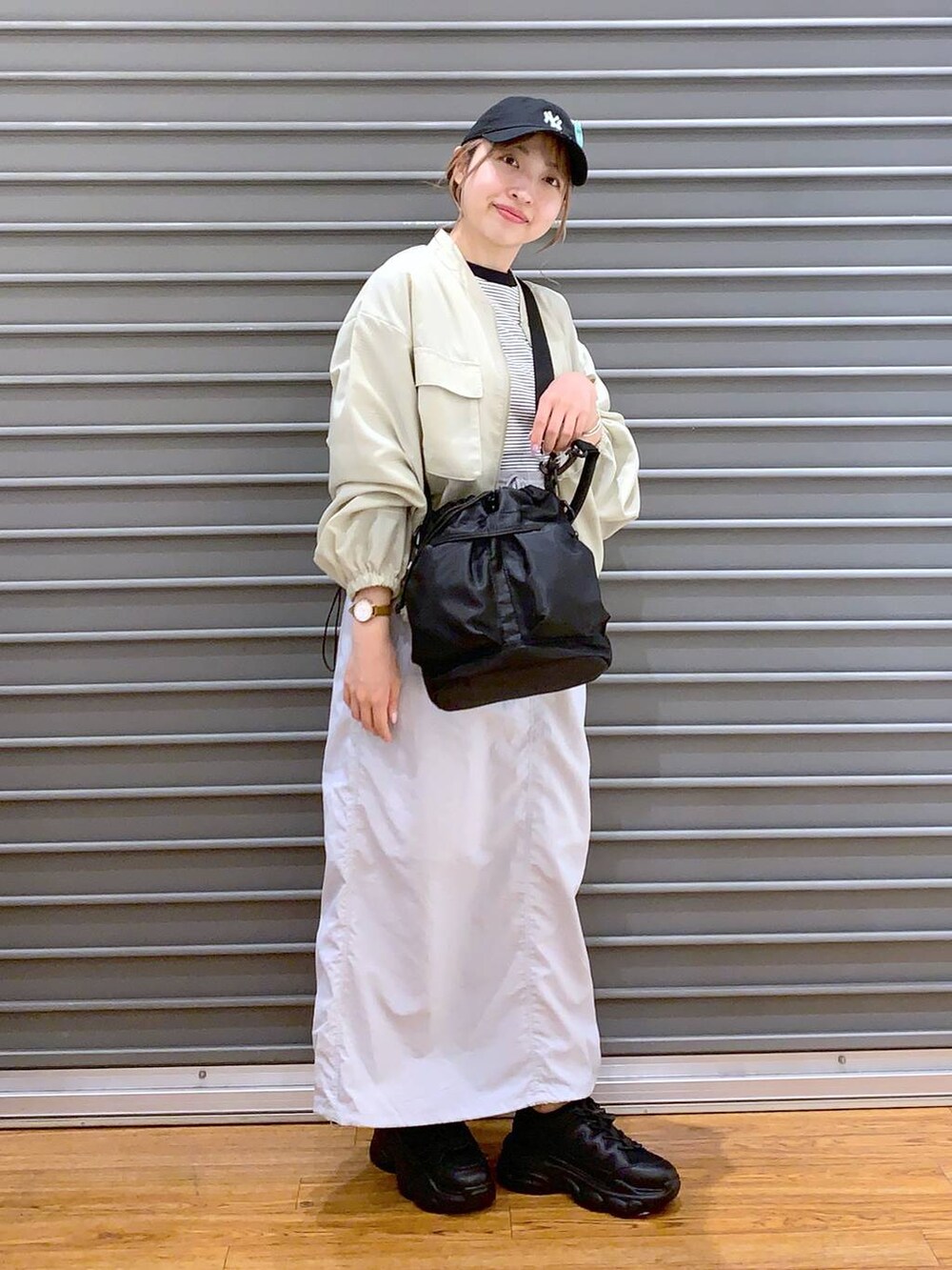 ブラック系のスニーカー、グレー系のTシャツ/カットソー、グレー系のスカートを着用したレディースの春コーディネートの9枚目の写真