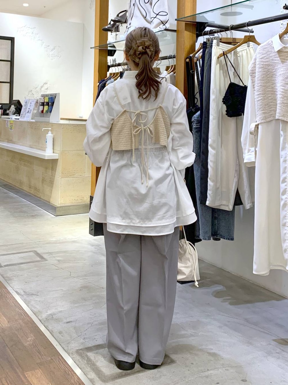 グレー系のその他パンツ、ホワイト系のその他トップス、ホワイト系のショルダーバッグを着用したレディースの春コーディネートの2枚目の写真