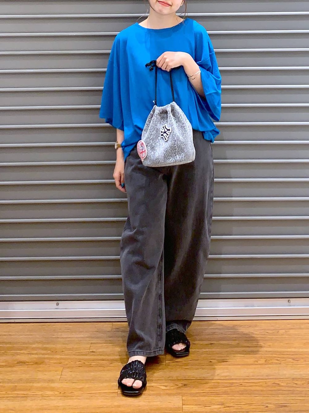 ブルー系のTシャツ/カットソー、グレー系のショルダーバッグ、ブラック系のデニムパンツを着用したレディースの夏コーディネートの6枚目の写真