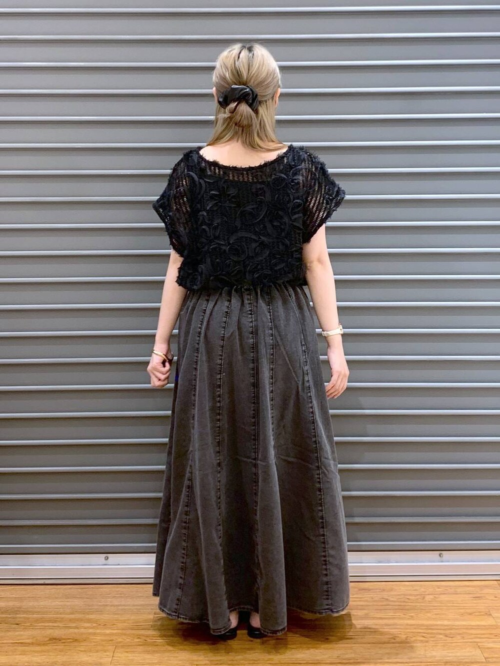ブラック系のショルダーバッグ、グレー系のスカート、ブラック系のサンダルを着用したレディースの夏コーディネートの2枚目の写真
