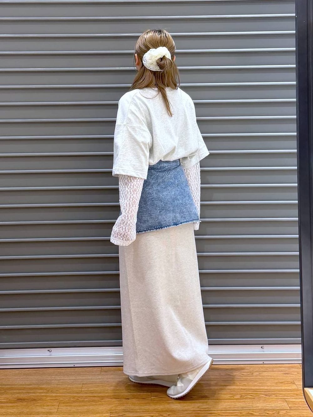 ベージュ系のスカート、ホワイト系のスニーカー、グレー系のショルダーバッグを着用したレディースの春コーディネートの3枚目の写真