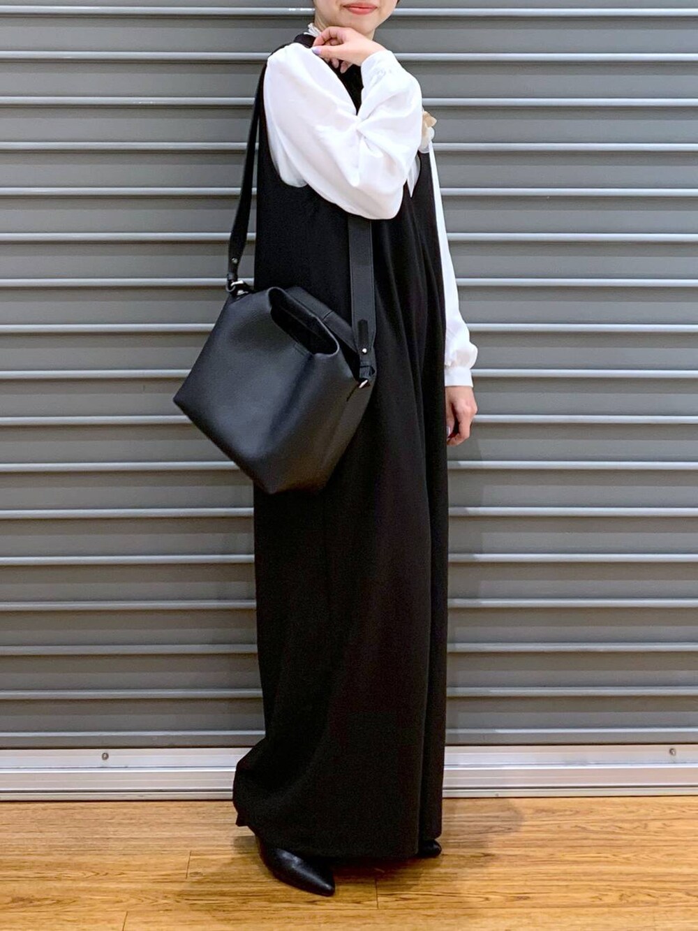 ホワイト系のシャツ/ブラウス、ブラック系のサロペット/オーバーオール、ブラック系のパンプスを着用したレディースの冬コーディネートの4枚目の写真