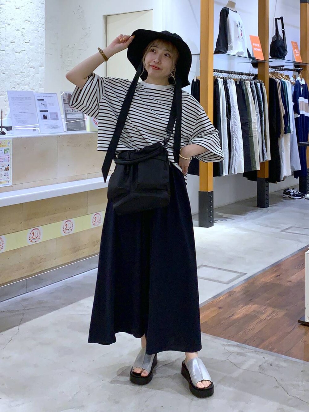 ブラック系のショルダーバッグ、グレー系のサンダル、グレー系のTシャツ/カットソーを着用したレディースの春コーディネートの4枚目の写真