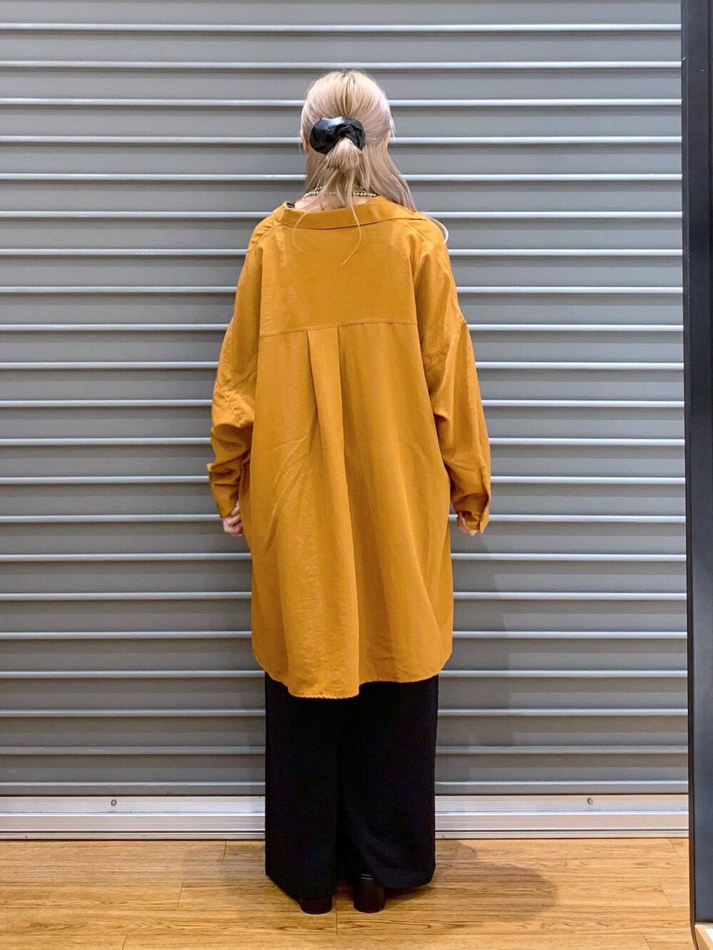 オレンジ系のシャツ/ブラウス、ブラック系のその他パンツ、グレー系のショルダーバッグを着用したレディースの秋コーディネートの2枚目の写真