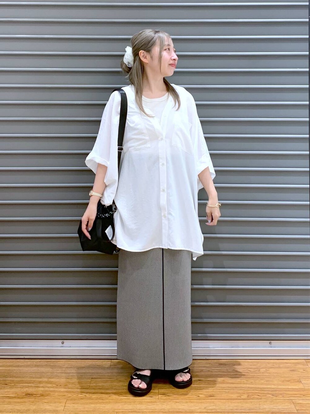 ホワイト系のTシャツ/カットソー、ブラック系のスカート、ブラック系のサンダルを着用したレディースの夏コーディネートの6枚目の写真