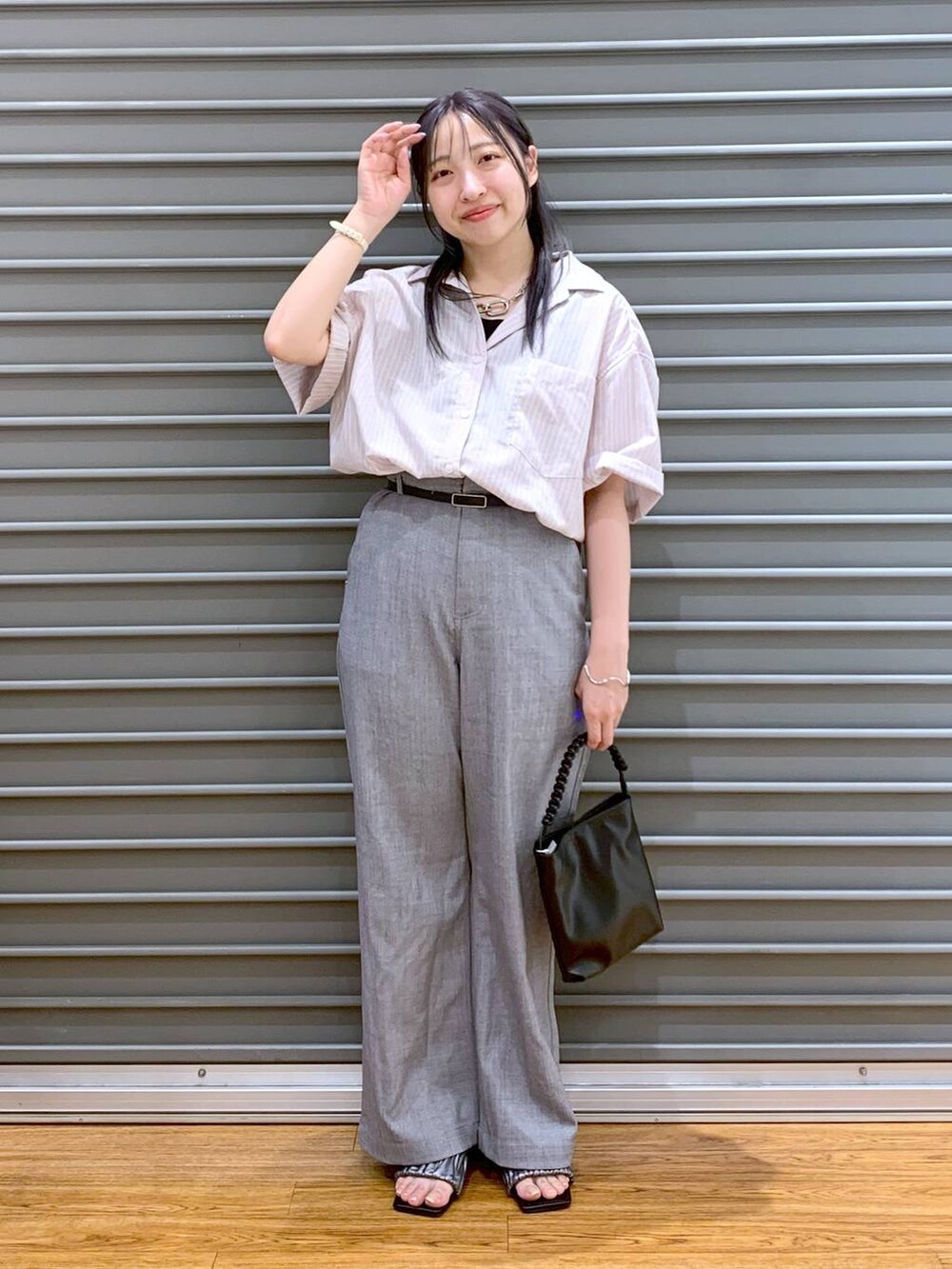 ピンク系のシャツ/ブラウス、グレー系のその他パンツ、ブラック系のショルダーバッグを着用したレディースの夏コーディネートの4枚目の写真