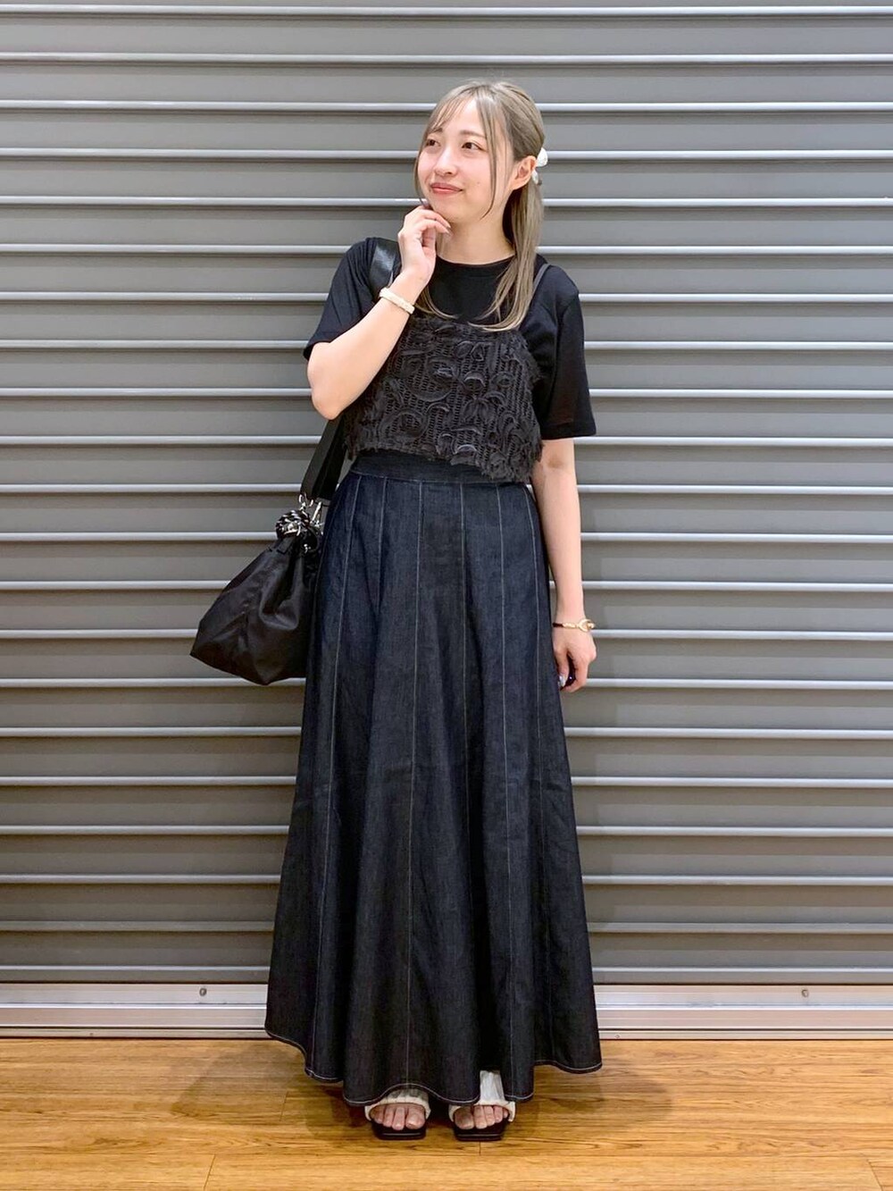 ブルー系のスカート、ホワイト系のサンダル、ブラック系のショルダーバッグを着用したレディースの夏コーディネートの4枚目の写真