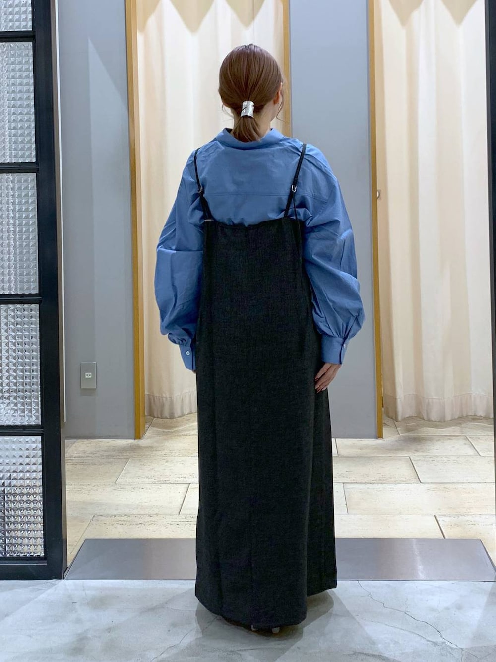 ブルー系のシャツ/ブラウス、ホワイト系のショルダーバッグ、ブラック系のワンピースを着用したレディースの春コーディネートの2枚目の写真