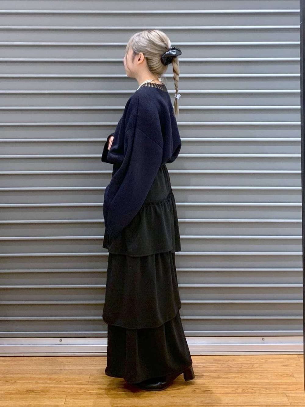 ブルー系のニット/セーター、グレー系のショルダーバッグ、ブラック系のブーツを着用したレディースの冬コーディネートの3枚目の写真