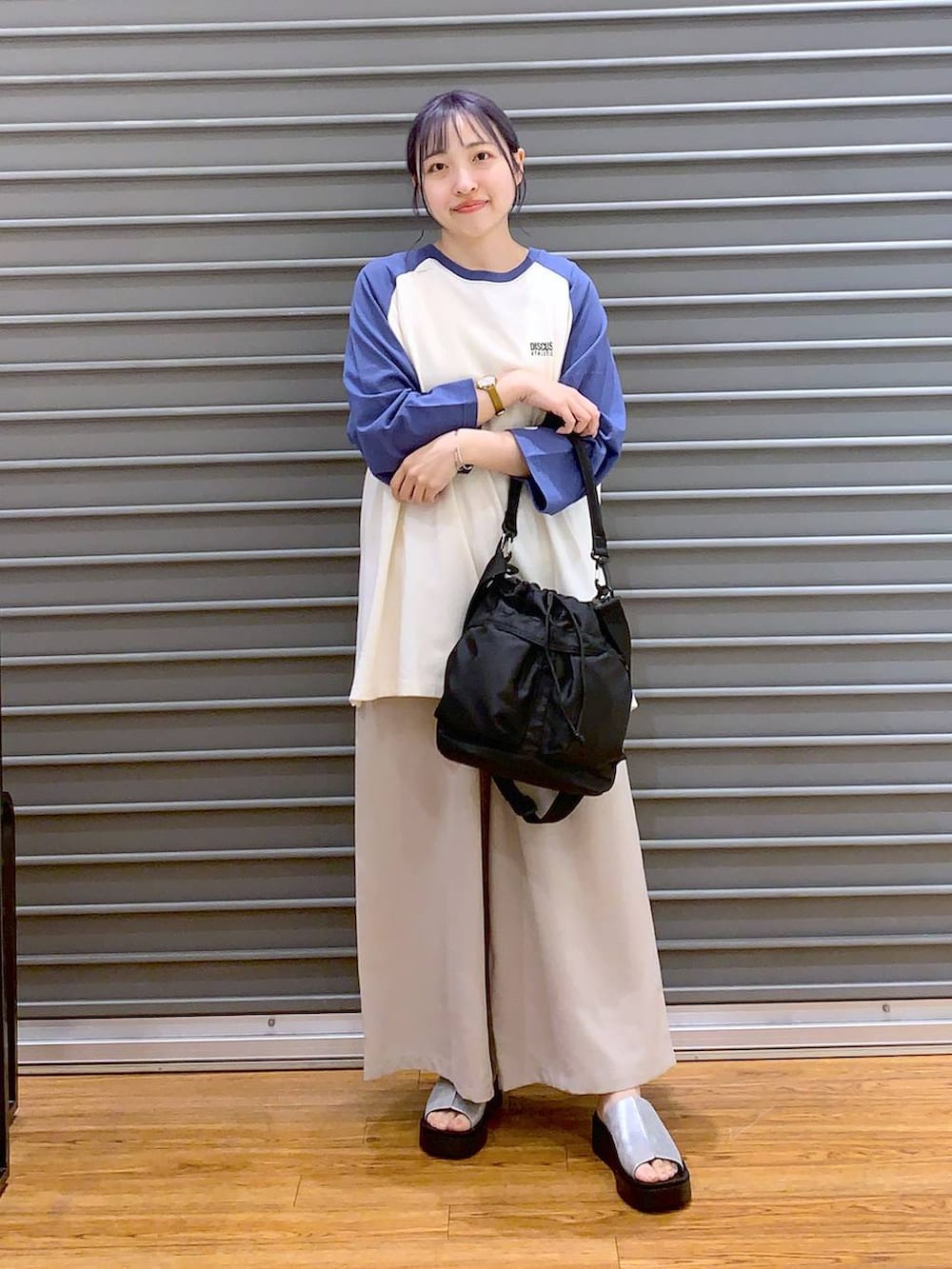 ブルー系のTシャツ/カットソー、ベージュ系のその他パンツ、ブラック系のショルダーバッグを着用したレディースの春コーディネートの8枚目の写真