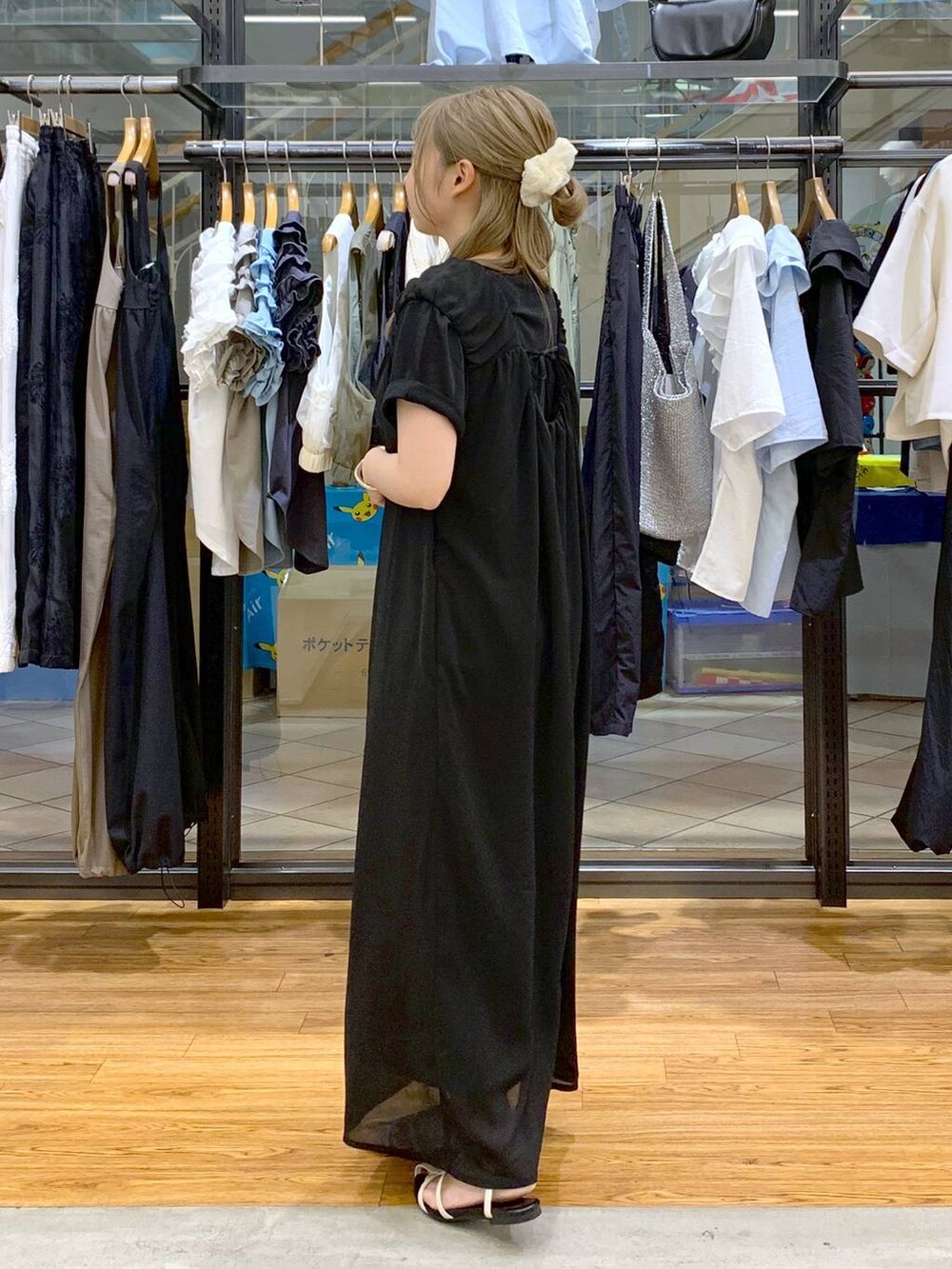 ホワイト系のサンダル、ホワイト系のショルダーバッグ、ブラック系のジャンパースカートを着用したレディースの夏コーディネートの3枚目の写真