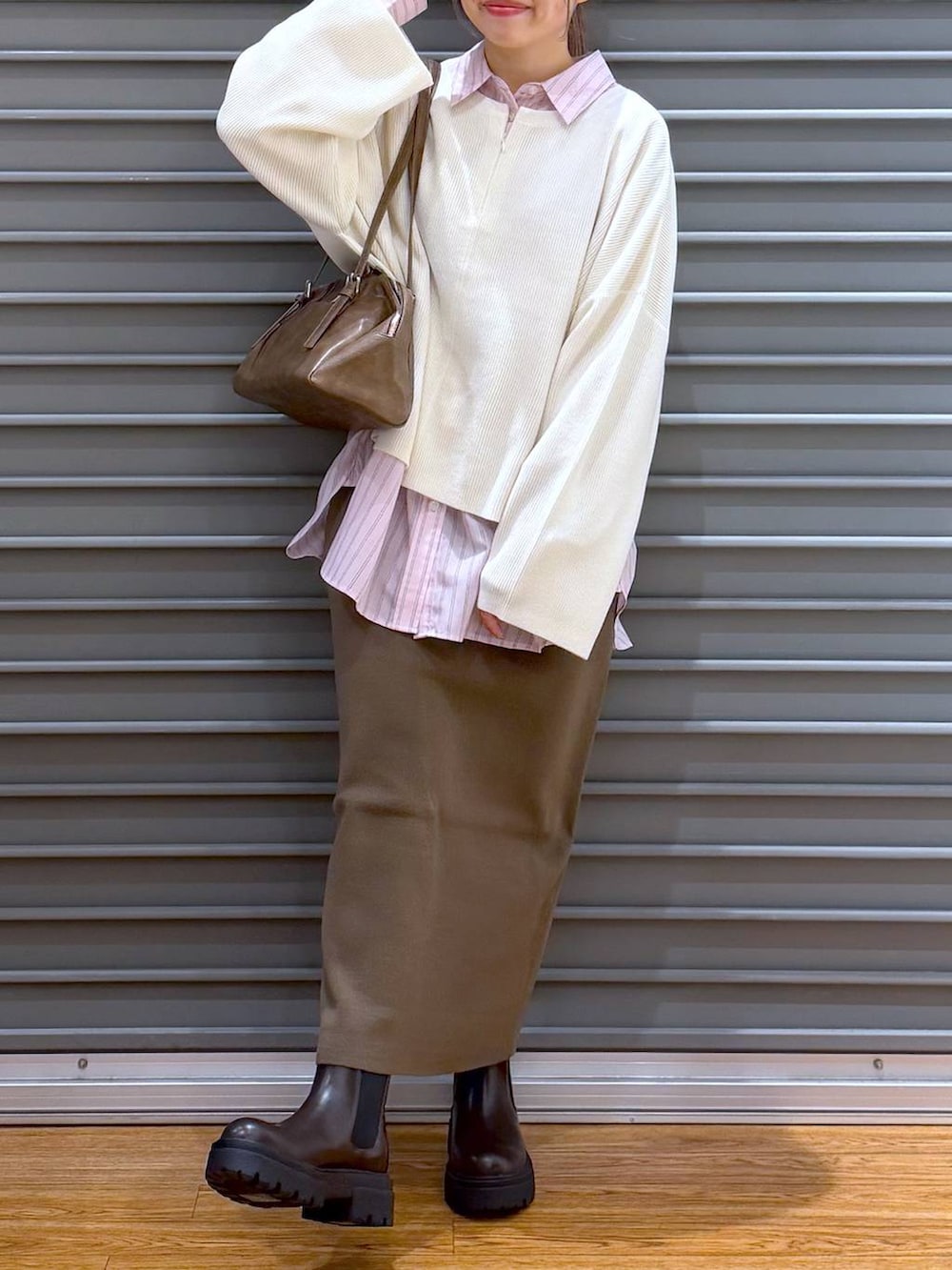 ブラウン系のスカート、ホワイト系のニット/セーター、ブラウン系のブーツを着用したレディースの冬コーディネートの5枚目の写真