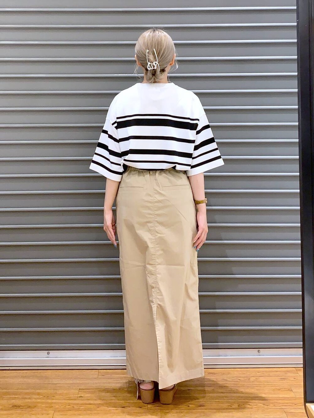 ベージュ系のスカート、シルバー系のサンダル、ホワイト系のニット/セーターを着用したレディースの夏コーディネートの2枚目の写真