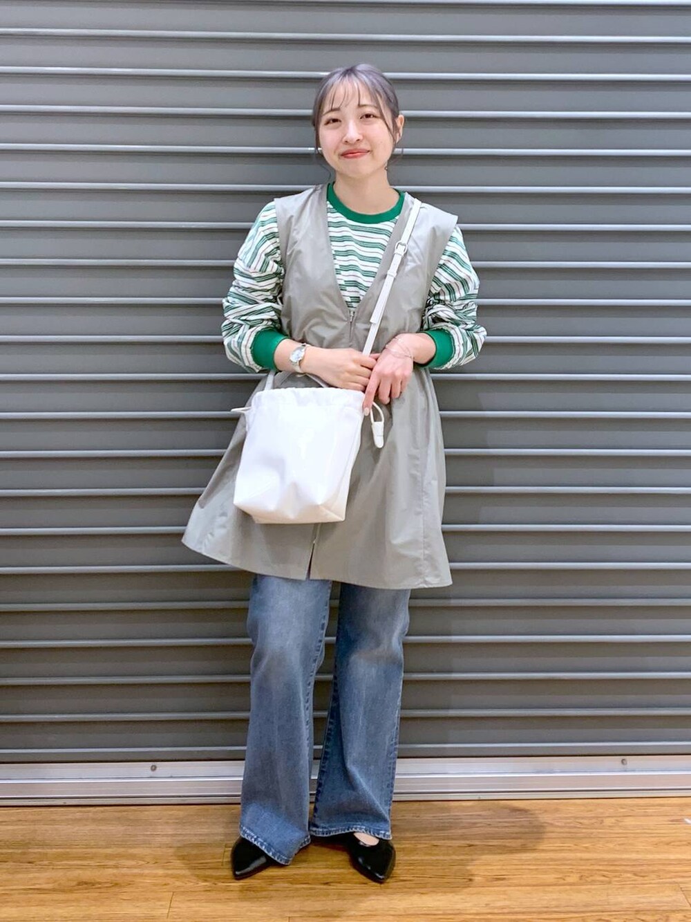 グリーン系のワンピース、ブルー系のデニムパンツ、ブラック系のパンプスを着用したレディースの春コーディネートの7枚目の写真