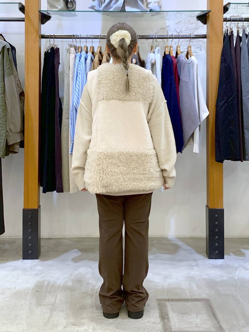 ブラウン系のその他パンツ、ブラック系のボストンバッグ、ホワイト系のベストを着用したレディースの秋コーディネートの2枚目の写真