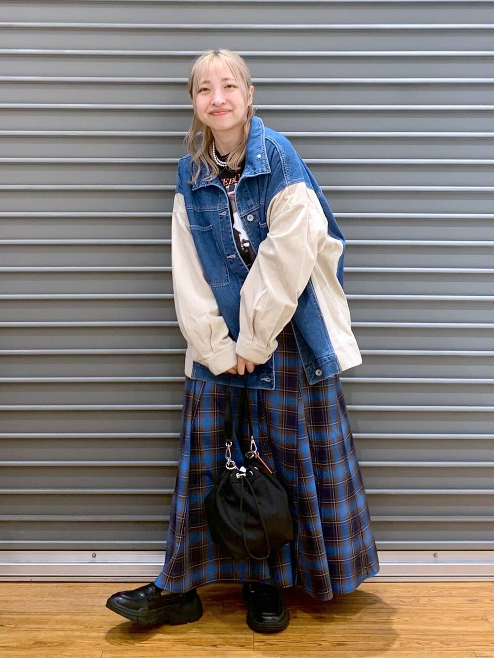 ブラック系のショルダーバッグ、ブラック系のスニーカー、ブルー系のカバーオールを着用したレディースの秋コーディネートの8枚目の写真