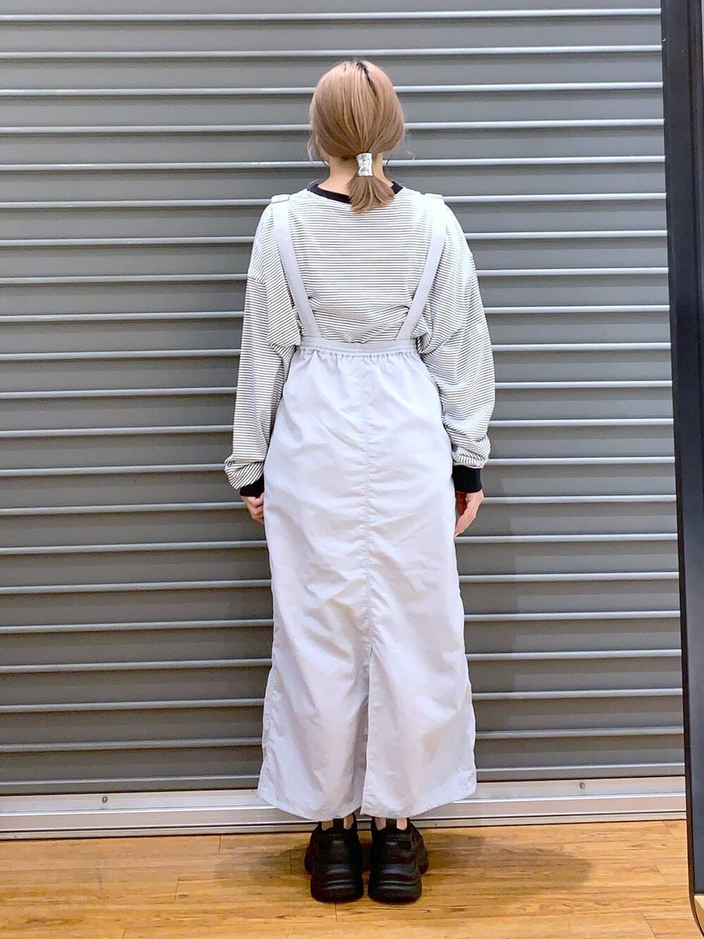 ブラック系のスニーカー、グレー系のTシャツ/カットソー、グレー系のスカートを着用したレディースの春コーディネートの3枚目の写真