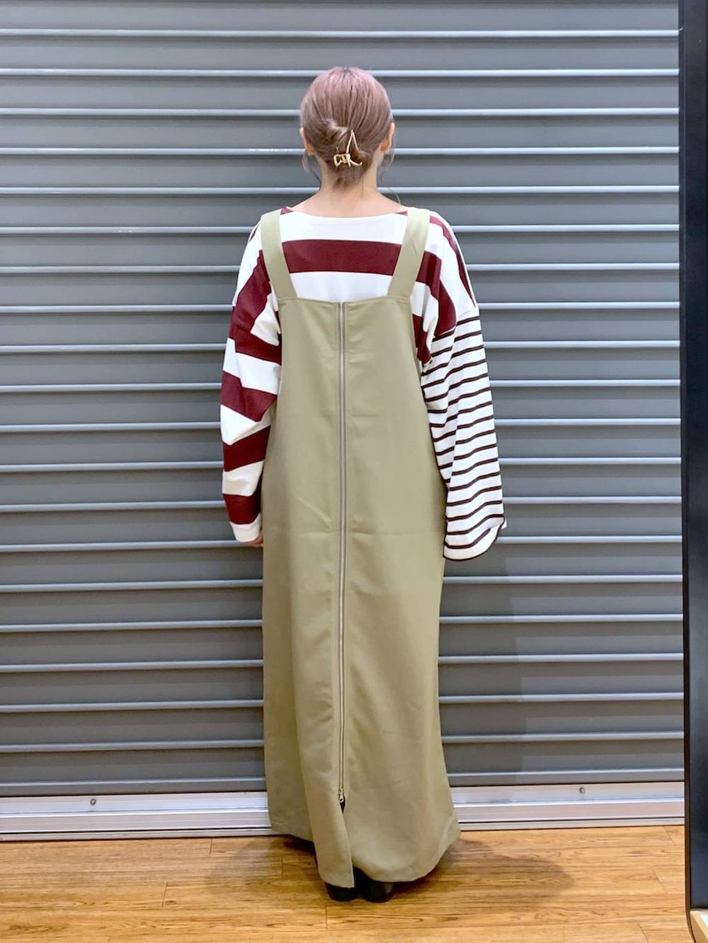 ホワイト系のショルダーバッグ、ブラック系のパンプス、ベージュ系のジャンパースカートを着用したレディースの秋コーディネートの2枚目の写真