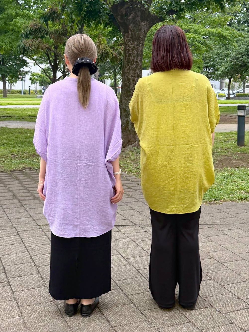 ブラック系のスカート、ブラック系のパンプス、ホワイト系のタンクトップを着用したレディースの春コーディネートの2枚目の写真