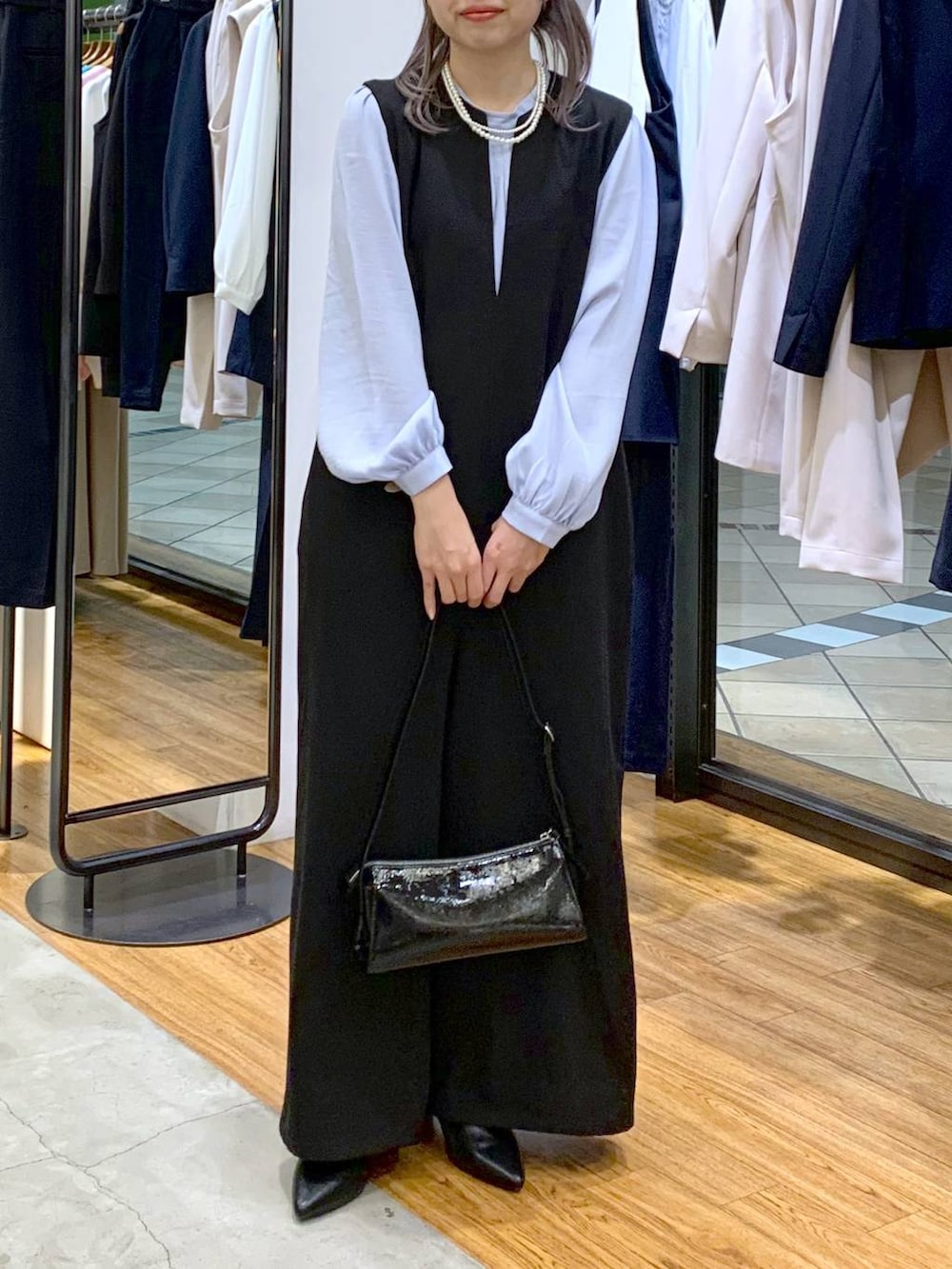 ブルー系のシャツ/ブラウス、ブラック系のサロペット/オーバーオール、ブラック系のパンプスを着用したレディースの冬コーディネートの3枚目の写真