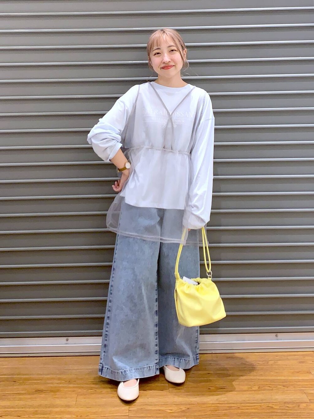 ブルー系のデニムパンツ、ホワイト系のバレエシューズ、イエロー系のショルダーバッグを着用したレディースの春コーディネートの7枚目の写真