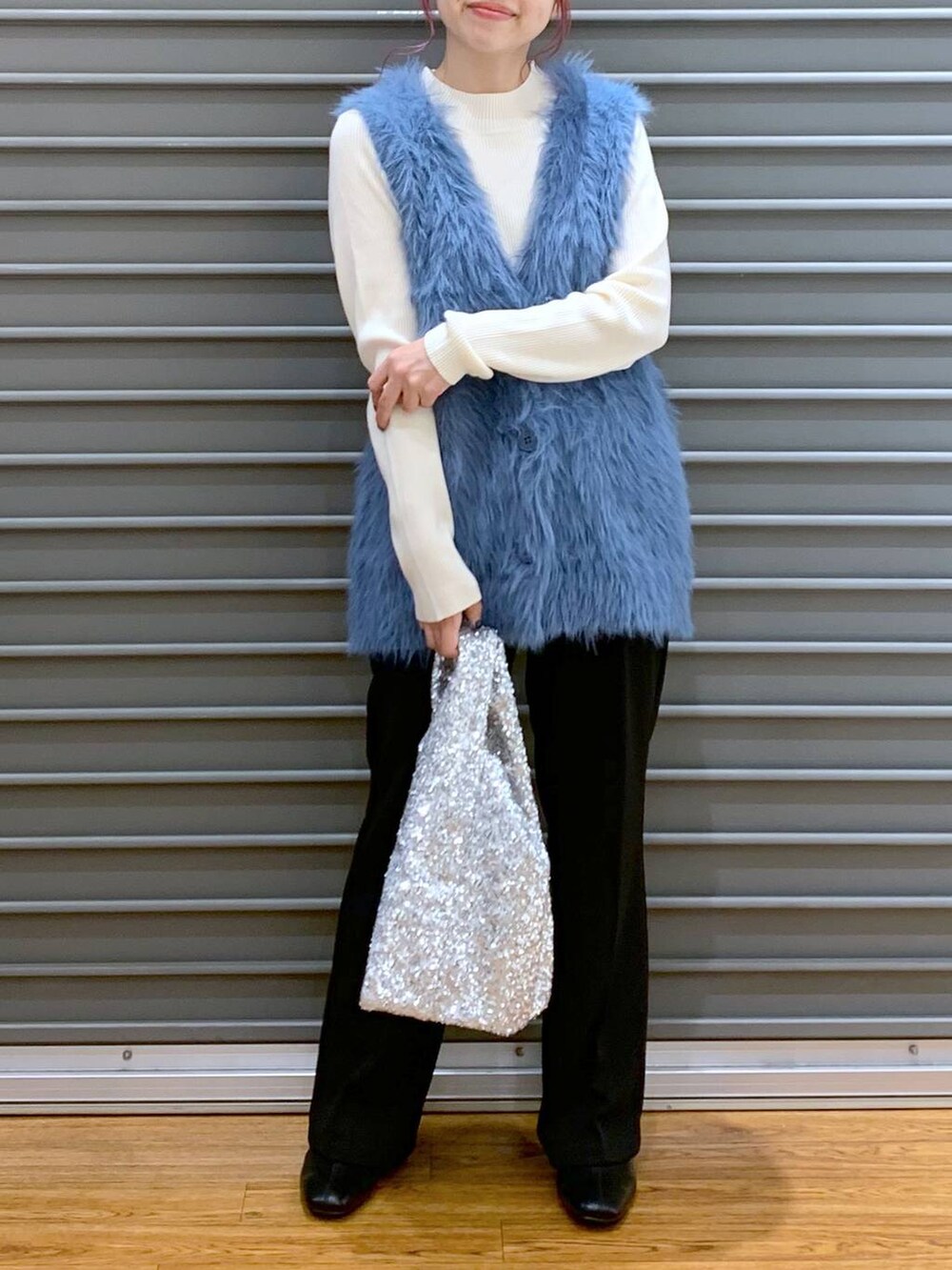 ホワイト系のニット/セーター、ブラック系のブーツ、ブルー系のベストを着用したレディースの秋コーディネートの5枚目の写真