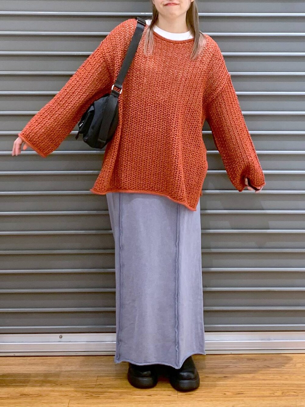 レッド系のニット/セーター、ブラック系のショルダーバッグ、ブラック系のサンダルを着用したレディースの春コーディネートの6枚目の写真