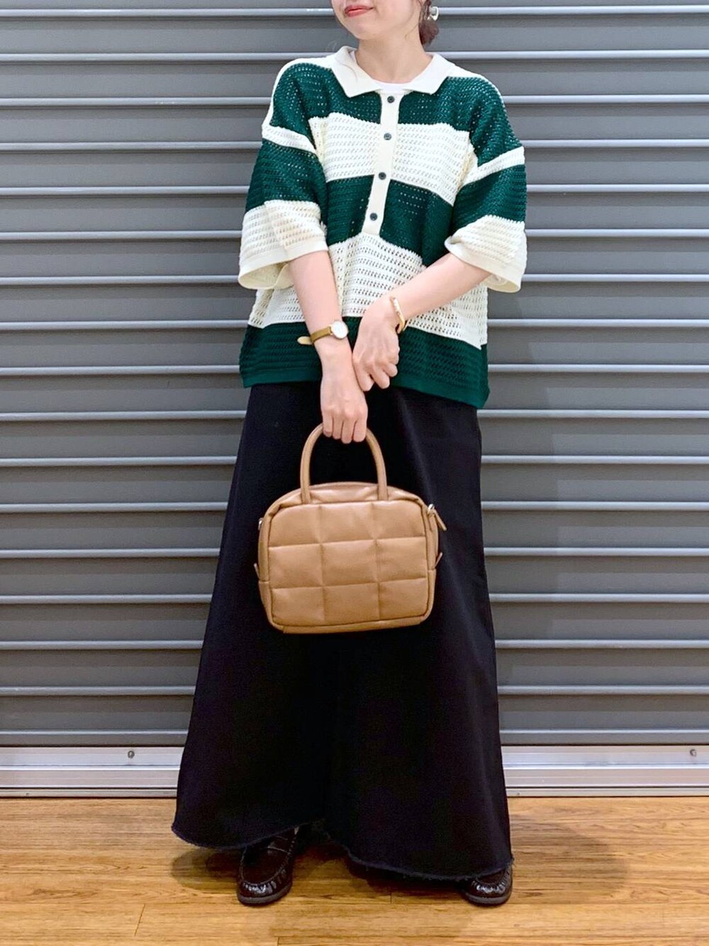 グリーン系のニット/セーター、グレー系のスカート、ブラウン系のボストンバッグを着用したレディースの秋コーディネートの4枚目の写真