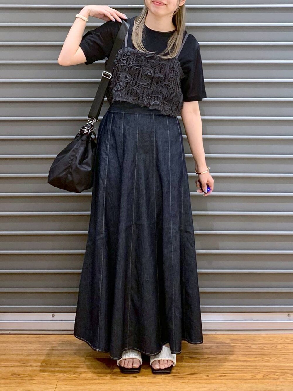 ブルー系のスカート、ホワイト系のサンダル、ブラック系のショルダーバッグを着用したレディースの夏コーディネートの5枚目の写真