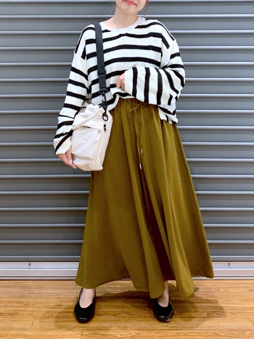 グリーン系のその他パンツ、ブラック系のパンプス、ホワイト系のショルダーバッグを着用したレディースの秋コーディネートの5枚目の写真