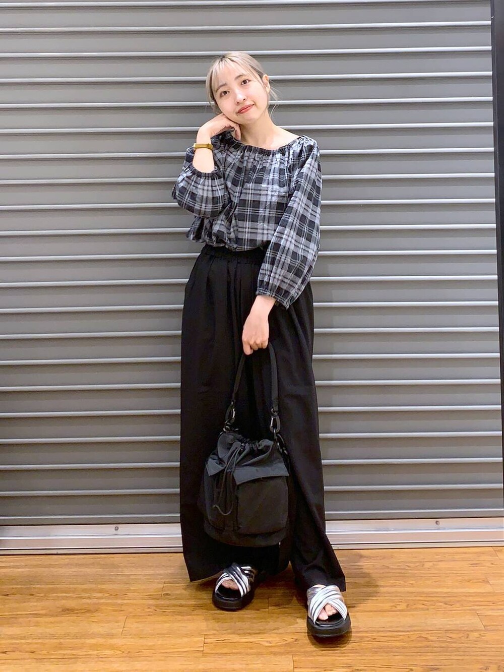 ブラック系のショルダーバッグ、シルバー系のサンダル、ブラック系のスラックスを着用したレディースの夏コーディネートの5枚目の写真