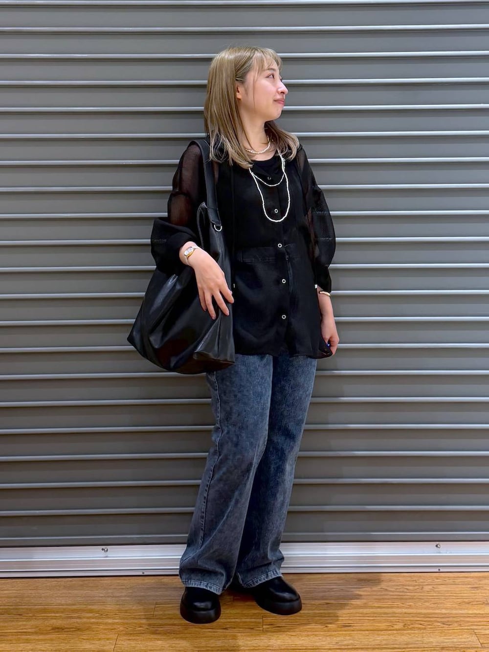 ブラック系のサンダル、ブルー系のデニムパンツ、グレー系のタンクトップを着用したレディースの春コーディネートの4枚目の写真