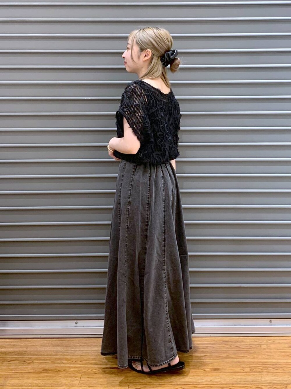 ブラック系のショルダーバッグ、グレー系のスカート、ブラック系のサンダルを着用したレディースの夏コーディネートの3枚目の写真