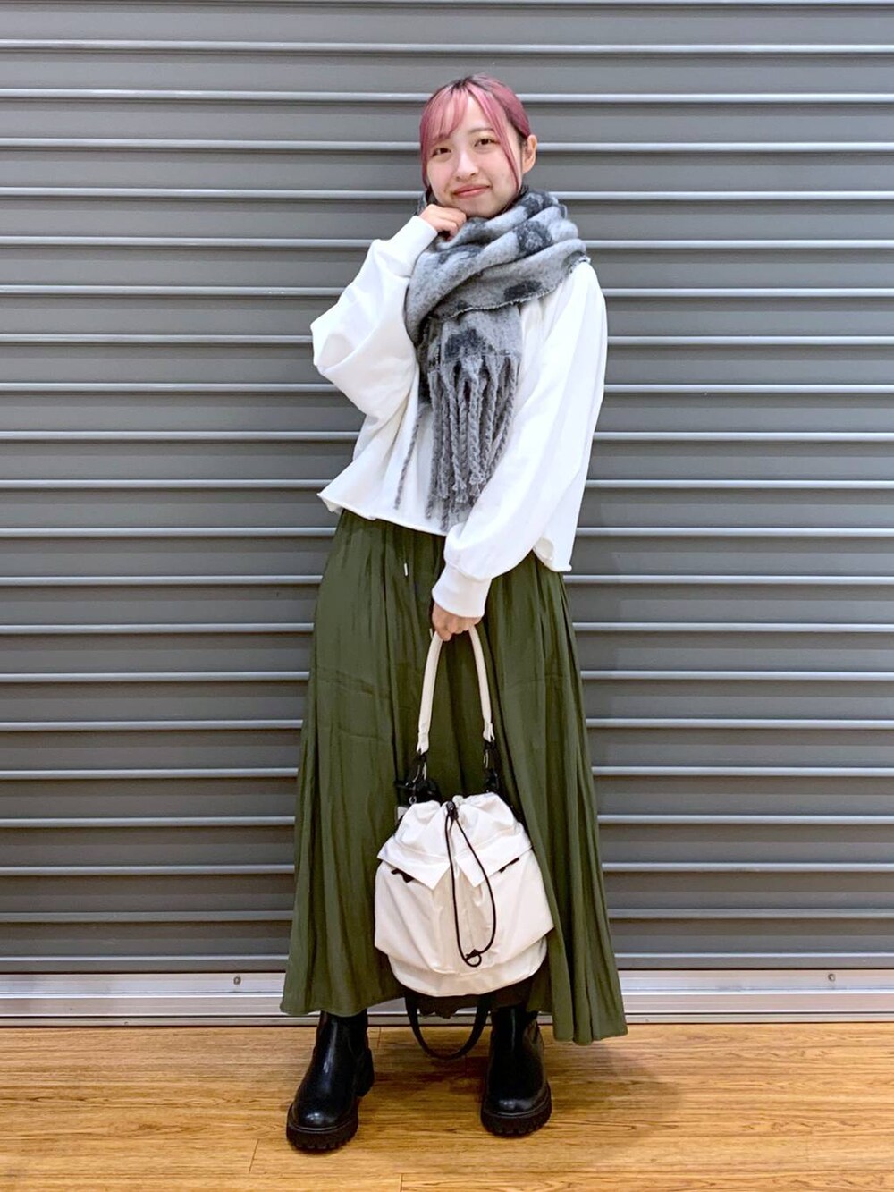 ホワイト系のショルダーバッグ、ブラック系のブーツ、ホワイト系のTシャツ/カットソーを着用したレディースの秋コーディネートの3枚目の写真