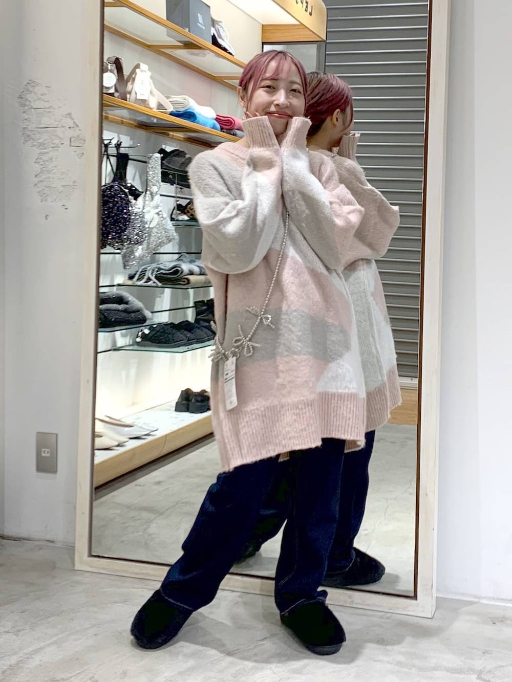 ブルー系のデニムパンツ、ブラック系のその他シューズ、ピンク系のチュニックを着用したレディースの秋コーディネートの5枚目の写真
