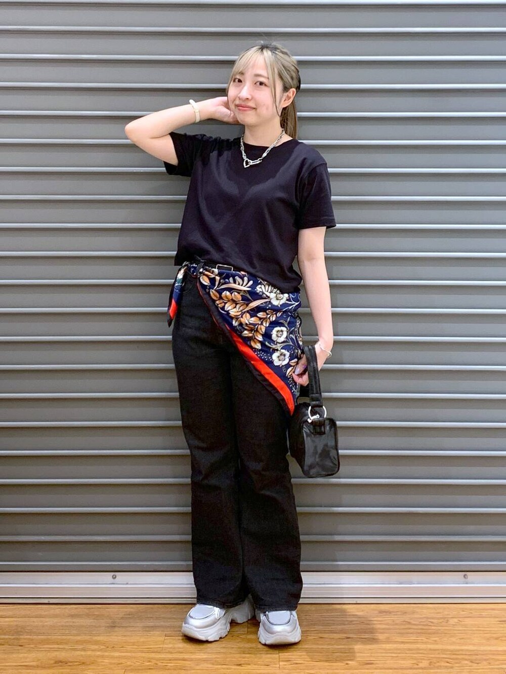 ブラック系のTシャツ/カットソー、ブラック系のデニムパンツ、シルバー系のスニーカーを着用したレディースの春コーディネートの5枚目の写真