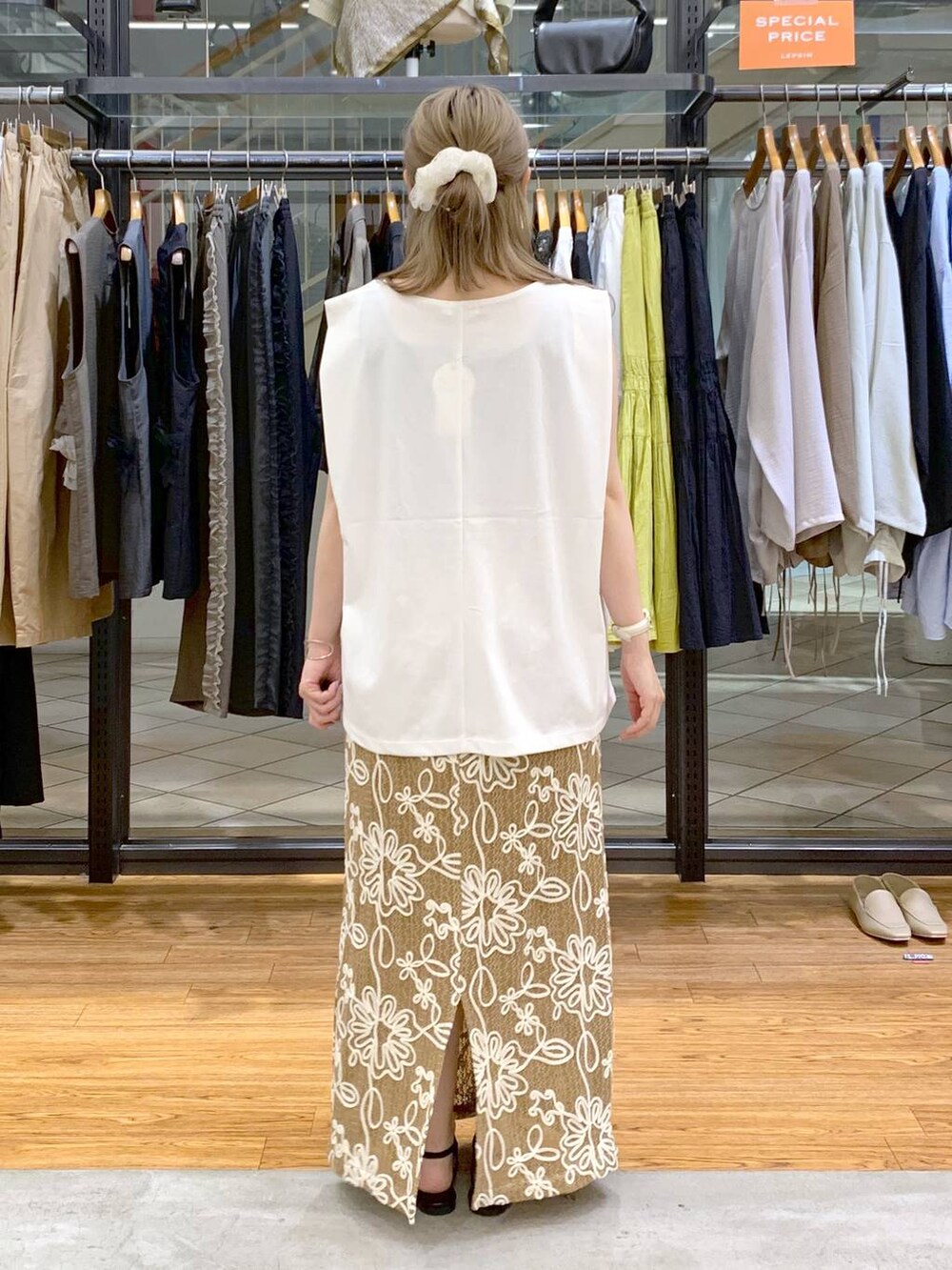 ホワイト系のTシャツ/カットソー、ブラック系のサンダル、ブラック系のショルダーバッグを着用したレディースの夏コーディネートの2枚目の写真