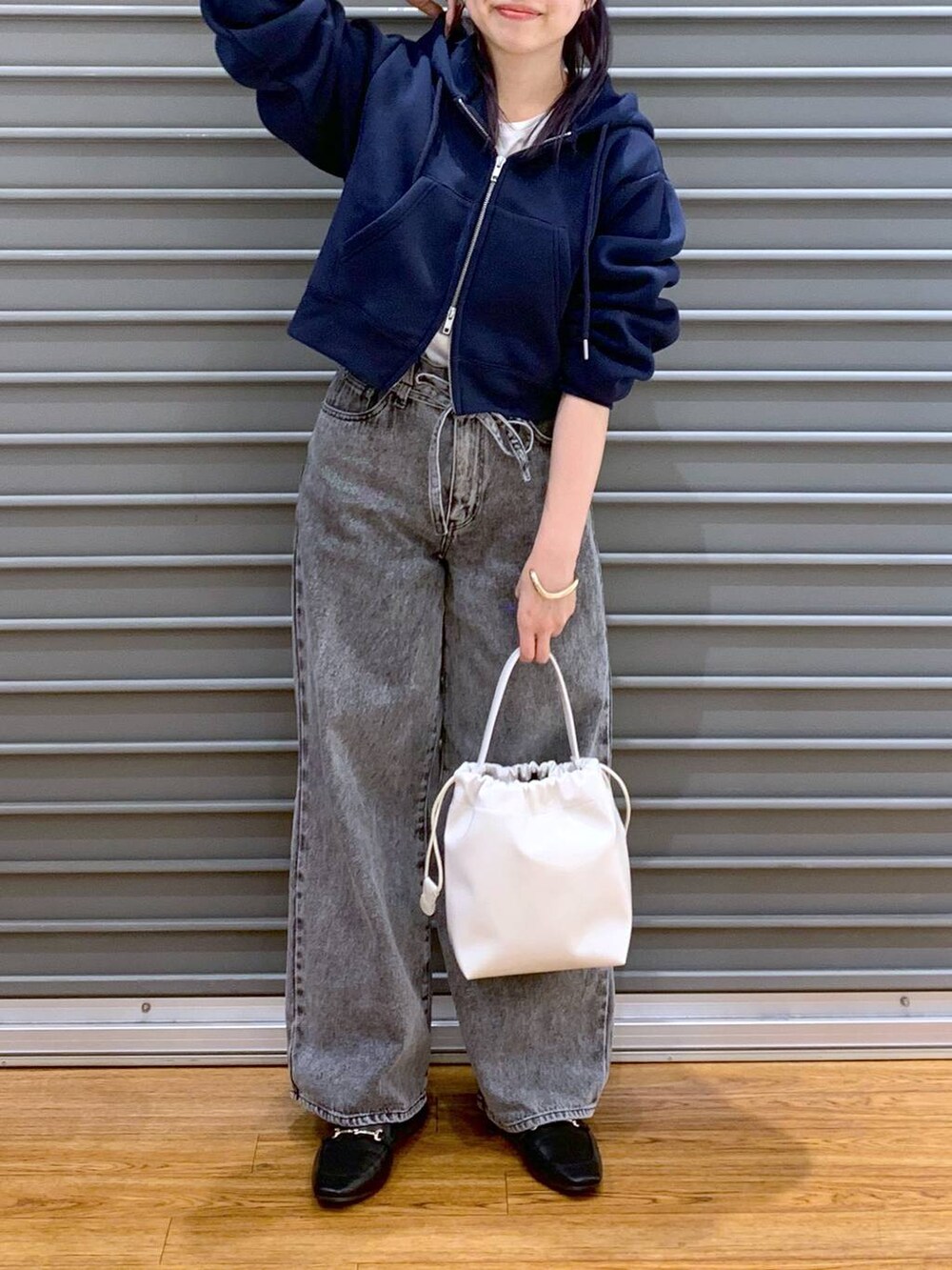 ブラック系のローファー、グレー系のデニムパンツ、ブルー系のパーカーを着用したレディースの春コーディネートの4枚目の写真